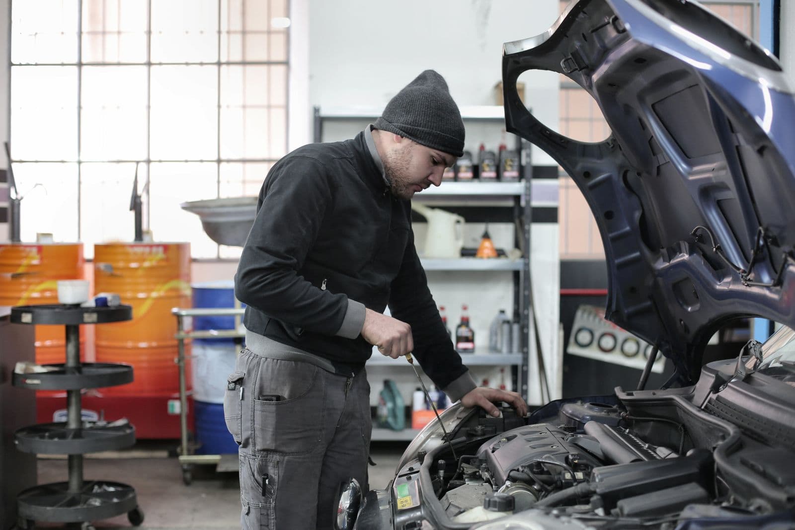 Mécanicien vérifiant le moteur d’un véhicule en atelier