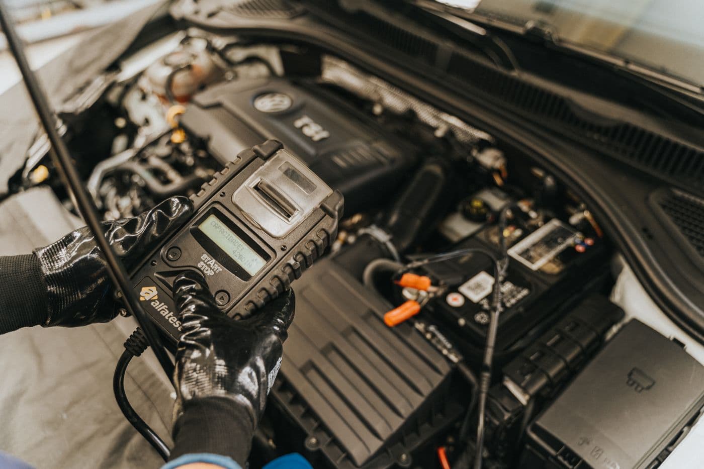 Technicien utilisant un véritable appareil de diagnostic dans le compartiment moteur
